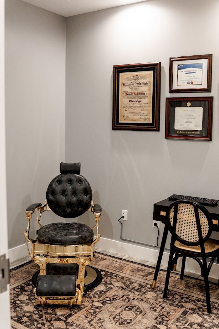 Framed dental qualifications on the wall at Soothing Dental above an antique leather chair