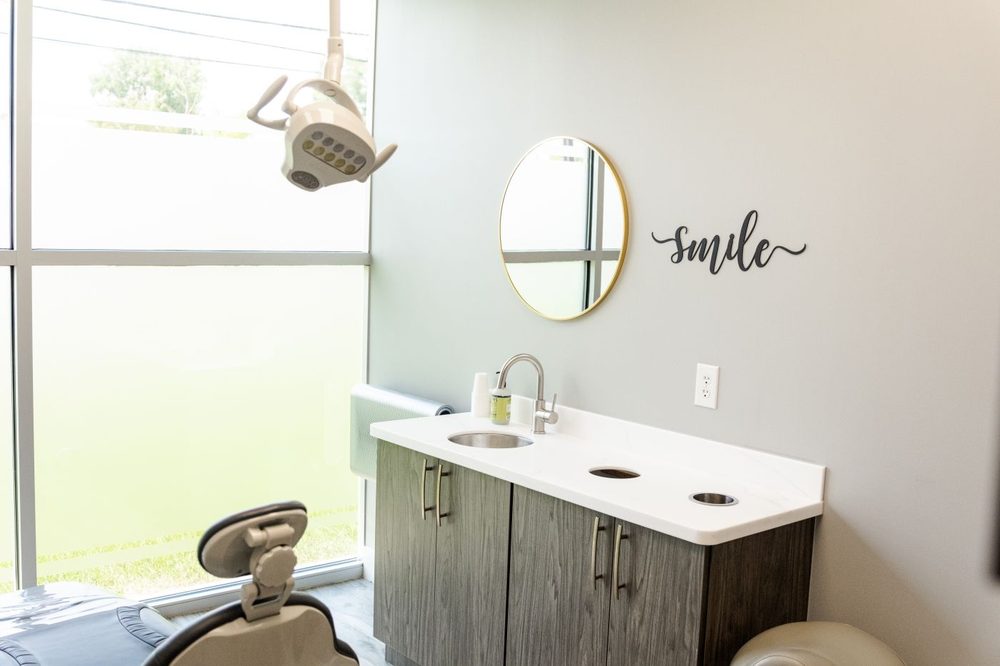 A Soothing Dental treatment room beside a full-height window, with a "smile" sign on the wall